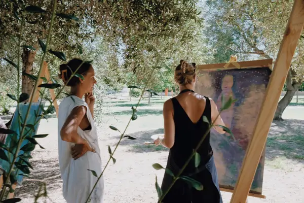 Two women admire art at Suniai Oliva Retreat Center in Spain, surrounded by nature, embodying the essence of peaceful retreats.