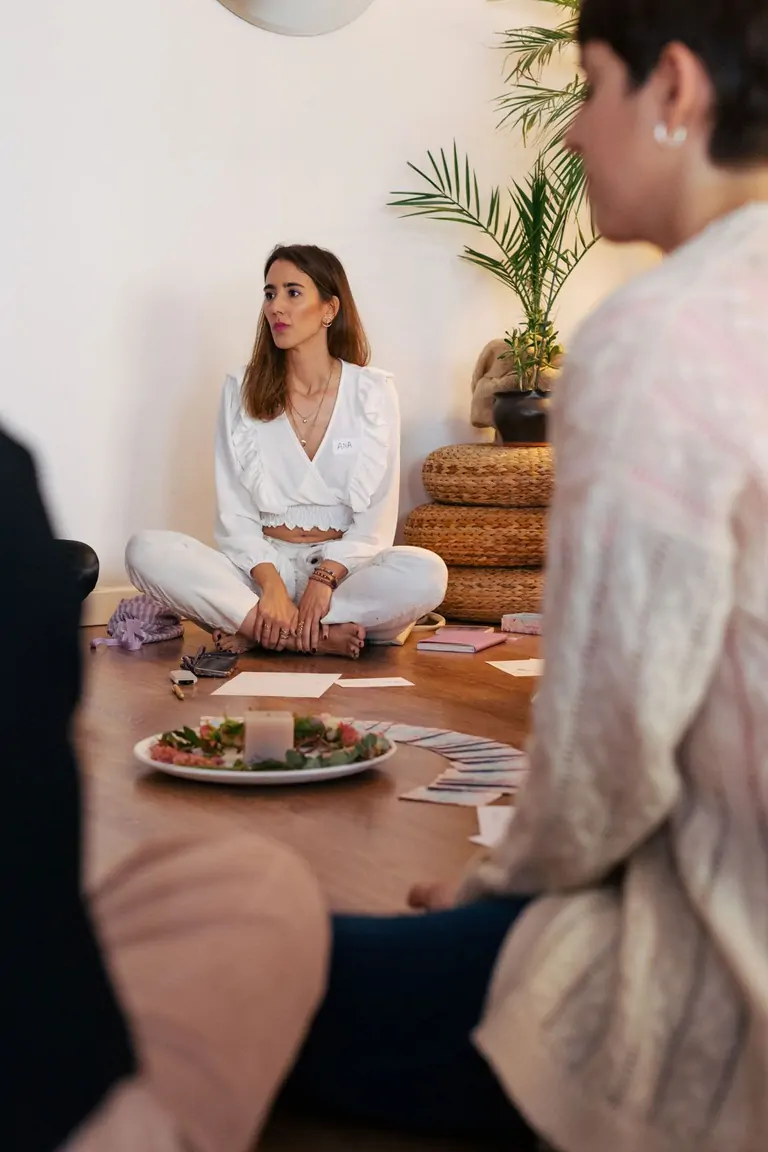 A vibrant gathering of people enjoying a meal, featuring fresh dishes at Suniai Oliva Retreat Centers communal table.