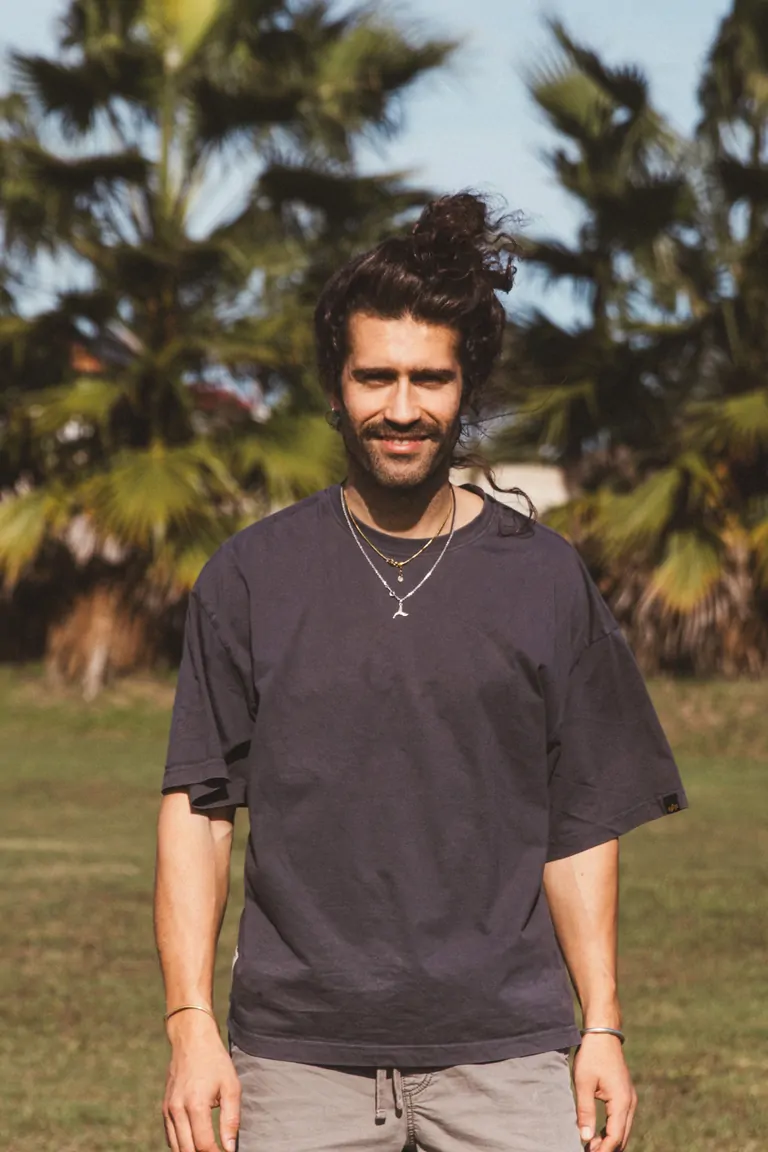 Marc, Marketing, Guest Relations & Photographer, smiles confidently against a backdrop of palm trees.