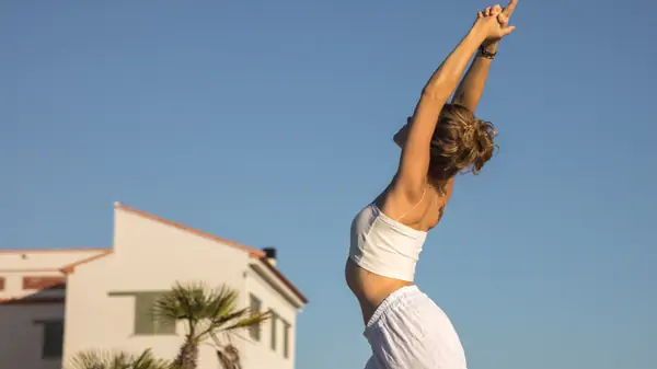 A yoga class in session at the Suniai Oliva Retreat Center, with participants stretching in a bright, airy studio.