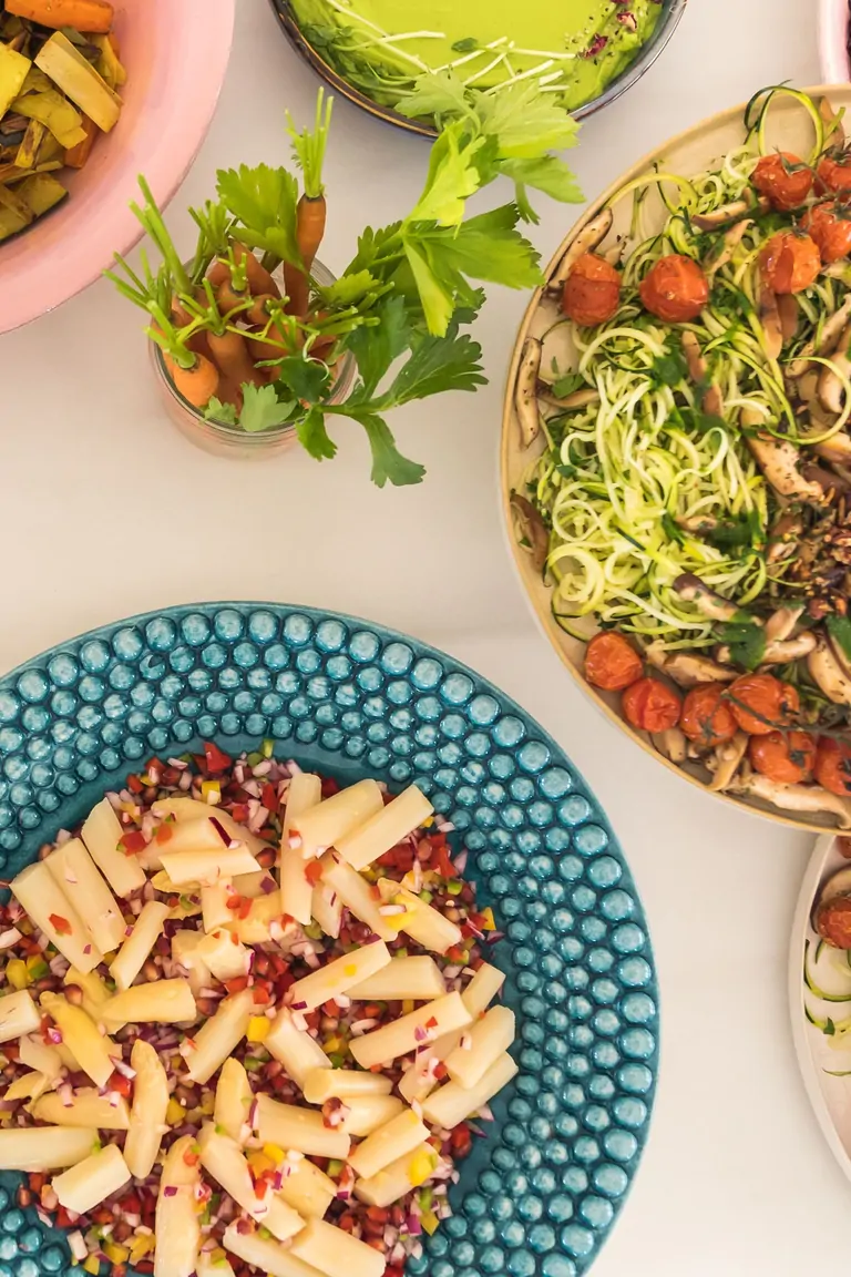 A colorful array of healthy dishes showcases the vibrant cuisine at Suniai Oliva Retreat Center, featuring fresh salads and sides.